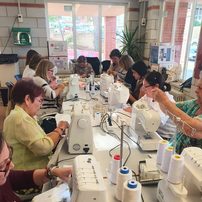 Persones participants a la primera edició cosint saquets, al Centre cívic Sant Pere i Sant Pau